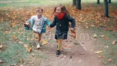 可爱的哥哥姐姐小男孩小女孩牵着手跑着，拿着玩具穿过公园里的秋巷